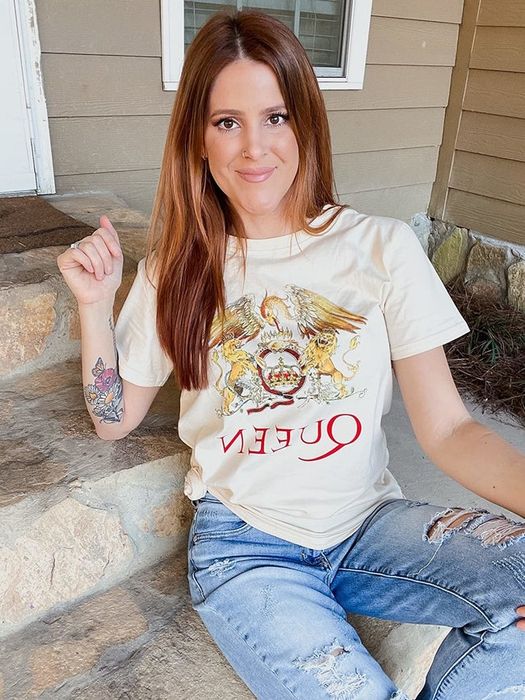 a reviewer modeling the beige Queen band tee