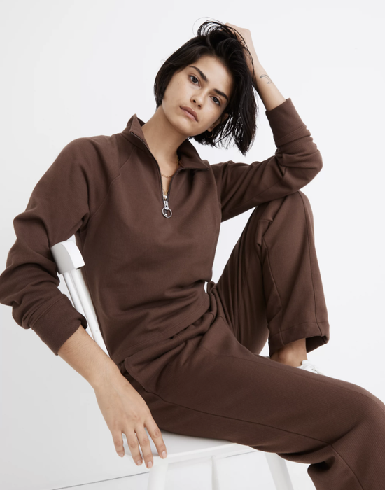 Model wearing a brown fleece-lined half-zip pullover from Madewell