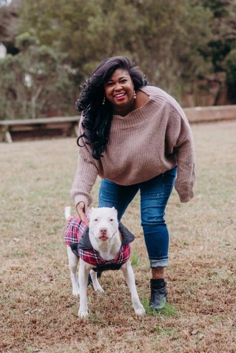 The reviewer sports a cozy brown sweater combined with classic denim jeans.