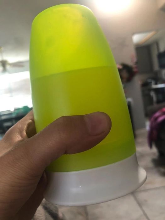 Reviewer's photo of the cup in Green, held upside down to showcase its leak-proof capabilities