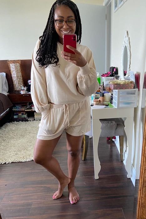 A reviewer wearing the cream-colored long-sleeve crop top paired with matching shorts
