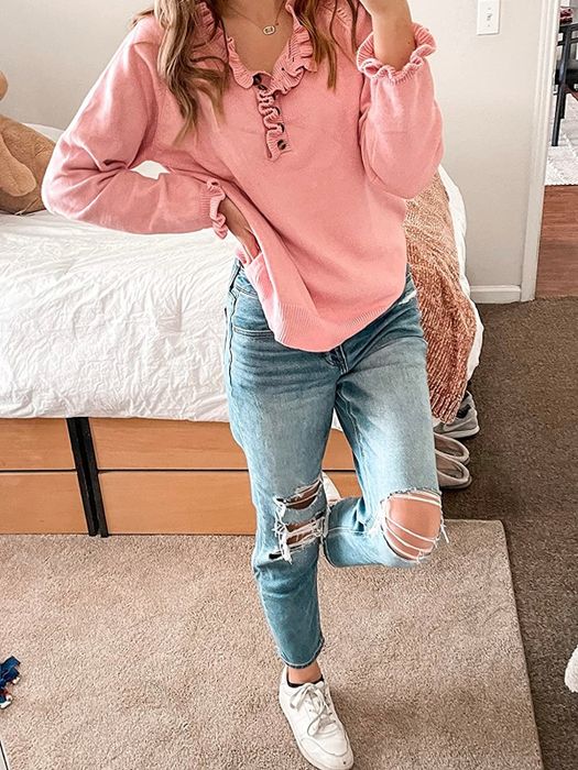 A reviewer styles a pink ruffled pullover with ripped jeans for a laid-back yet fashionable look.