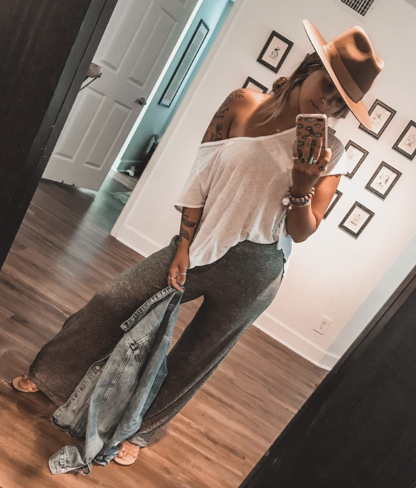 reviewer in gray lounge pants with a white top