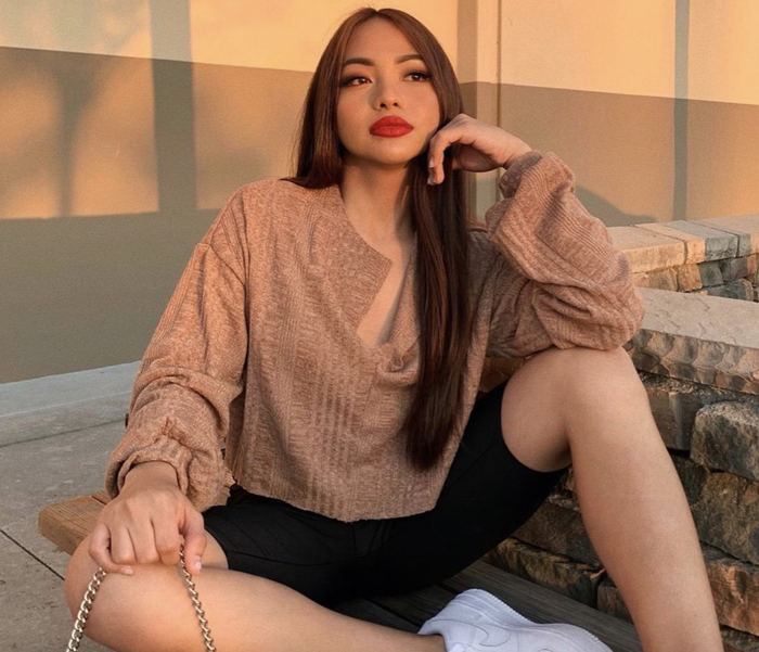 The reviewer is wearing the taupe top.