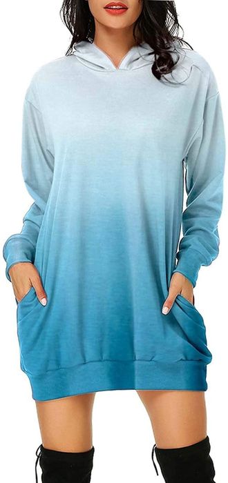 A model wearing the blue ombre hoodie minidress with hands in the pockets