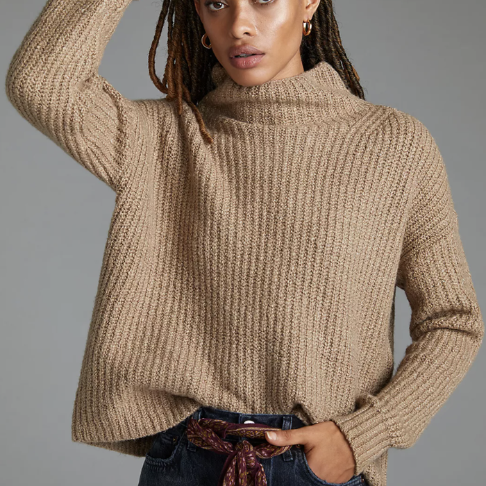 Model showcasing a taupe funnel-neck sweater