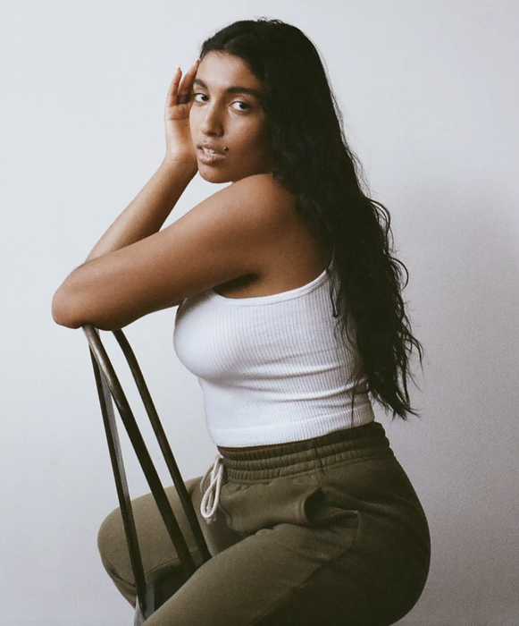 The model is wearing a white tank top.
