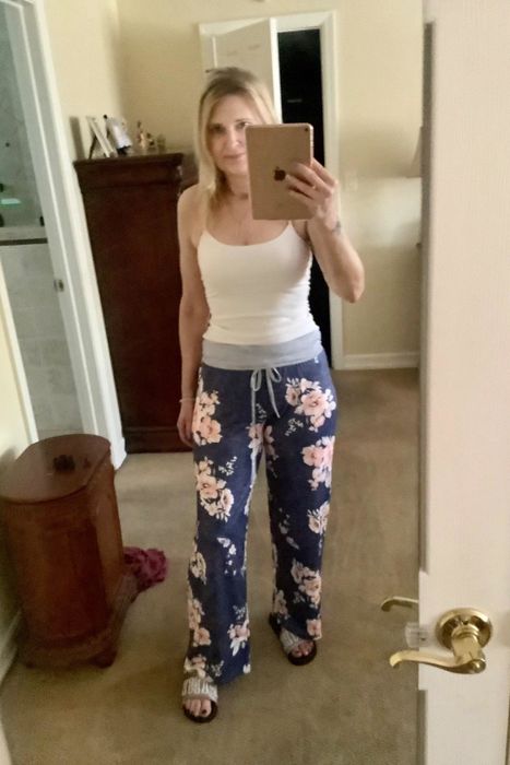 A reviewer wearing the navy and pink floral pants with a gray waistband