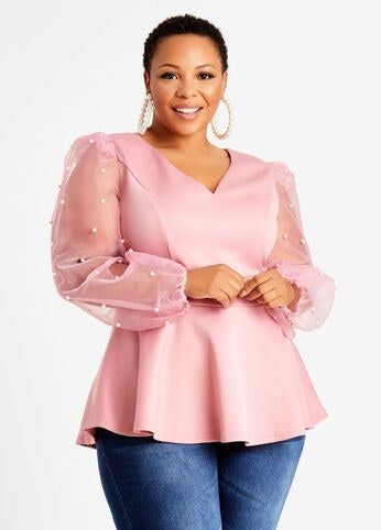 Blush-toned peplum design with whisper-thin translucent sleeves offering a feminine edge
