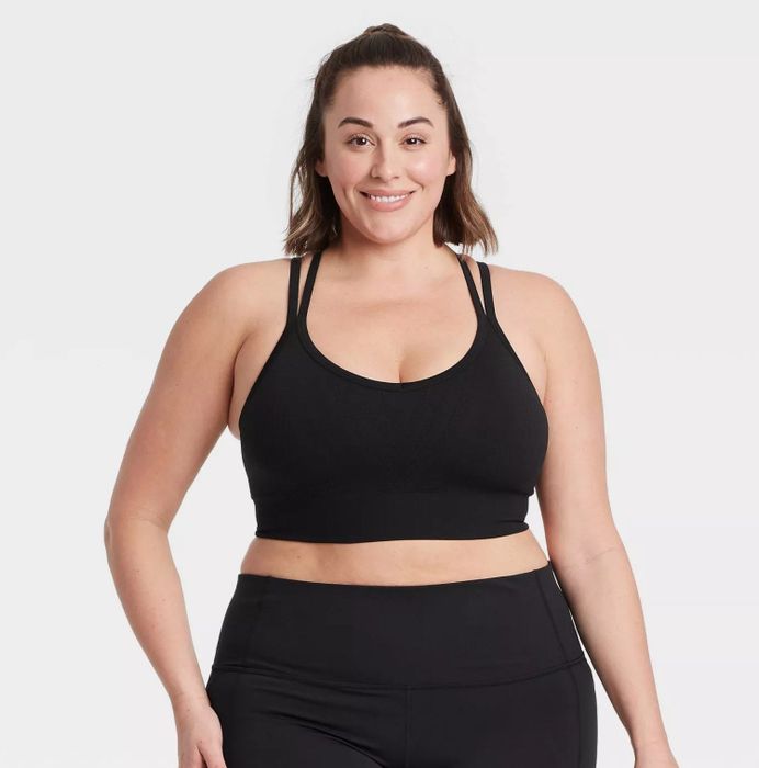 A model wearing the black sports bra paired with matching bottoms