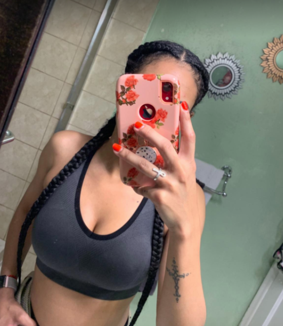 Reviewer models a navy blue high-impact sports bra in a mirror selfie