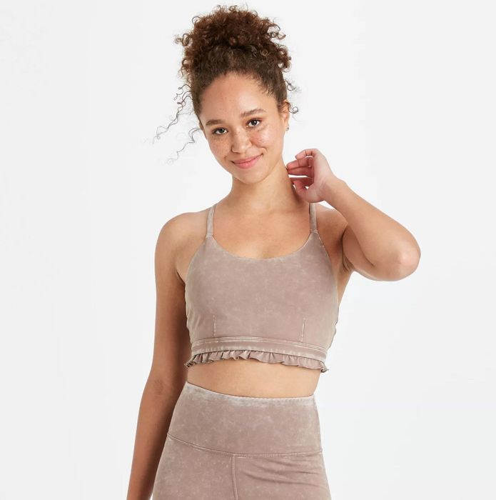A model wearing the pink velvet bra with ruffled detailing, paired with matching pink velvet bottoms