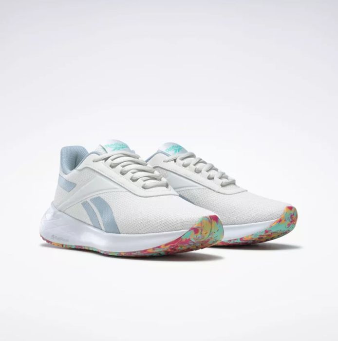 The sneakers in white with blue stripes and rainbow-colored soles