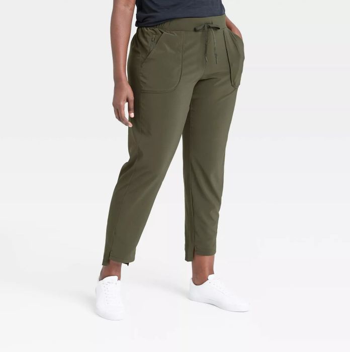 The model is wearing army green pants styled with white shoes and a navy blue top.