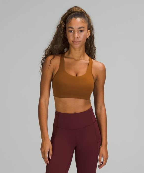 Model showcases a copper brown sports bra paired with berry-colored leggings