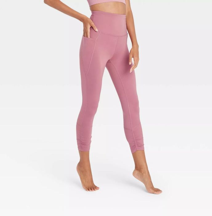 A model wearing the pink leggings, standing on their tiptoes