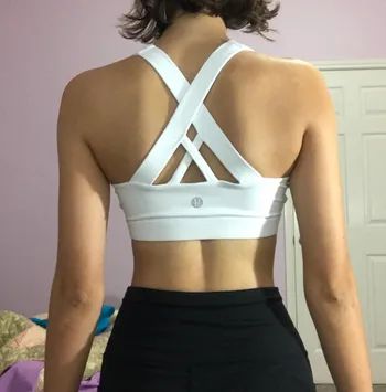 A reviewer turning around to showcase the interlocking white straps on the back