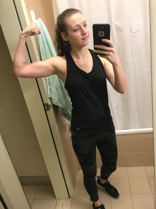 Reviewer flexing in a mirror selfie, wearing a tank top and casual pants