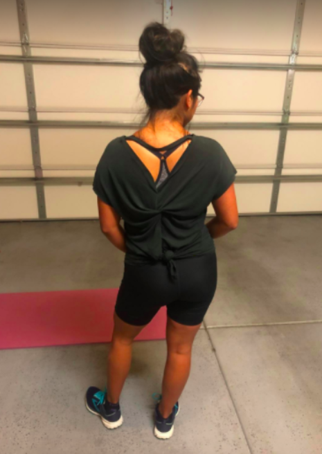 The reviewer spins around to display the intricate twist-back design of the same top.