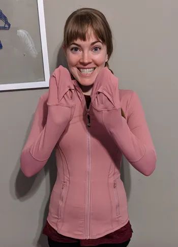 Reviewer in a pink hoodie with their hands snugly tucked into the sleeves, using them as makeshift mittens