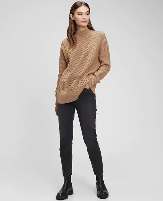 Editorial pairing of the camel knit with jet-black pants and combat boots for urban edge