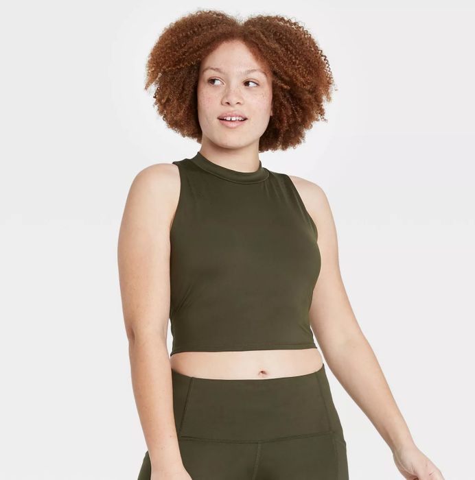 A model wearing the army green longline bra, cropped above the belly button, paired with matching bottoms