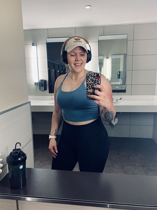 Reviewer models the same style tank top in a dark blue color