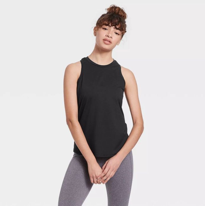 A model wearing the black racerback tank paired with gray leggings