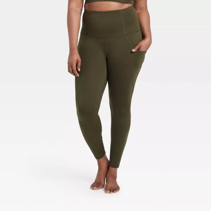 A model wearing the army green leggings with one hand casually placed in the side pocket