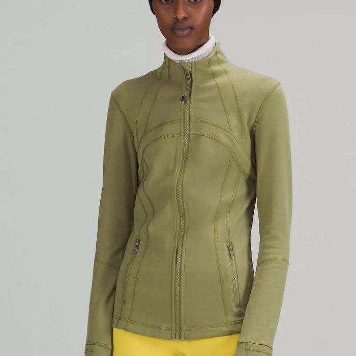 A model showcasing a zippered athletic jacket in a stylish olive green color.