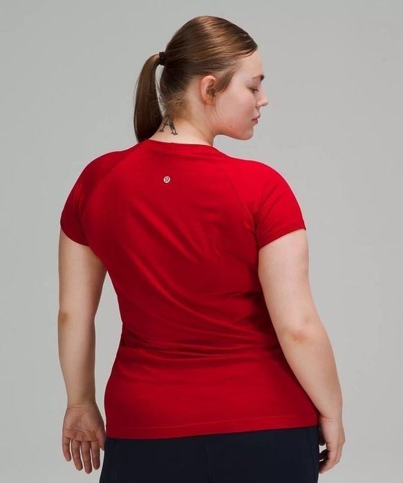 A model showcasing the back of a red shirt.