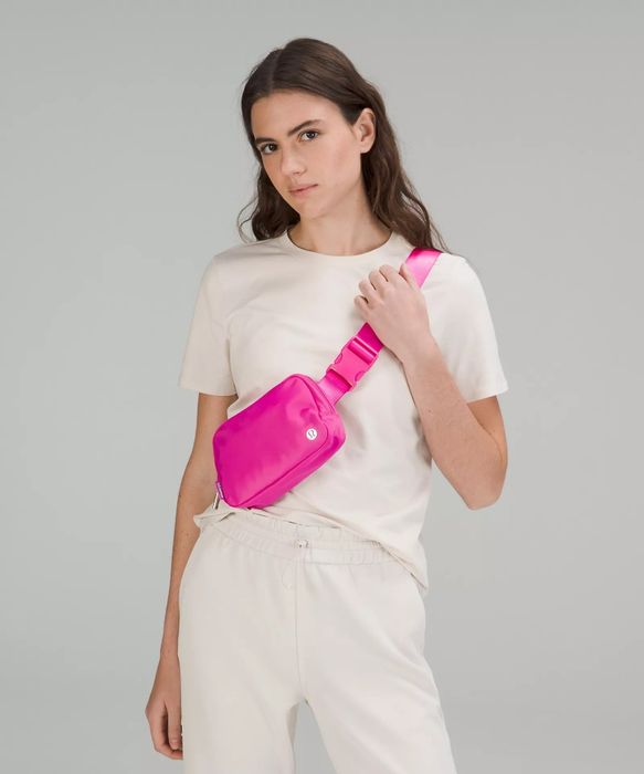 A model showcasing the pink bag worn across their chest.