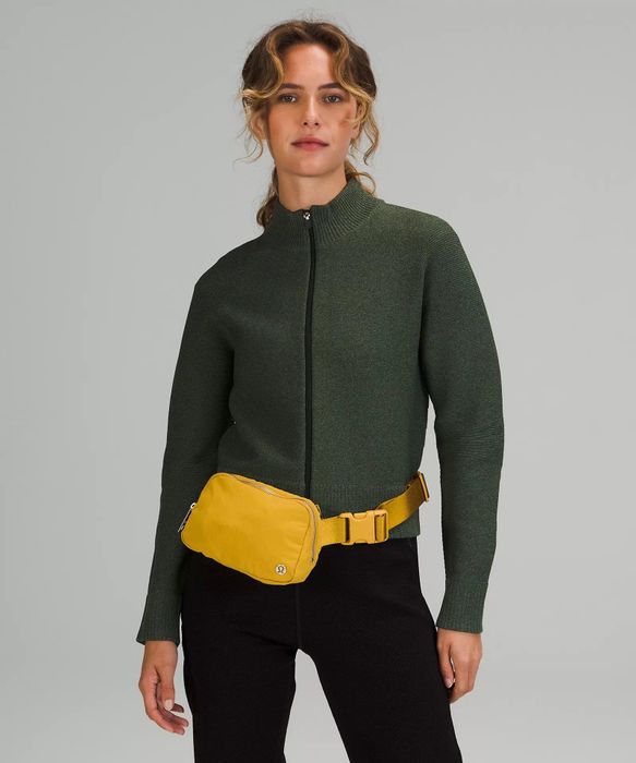A model wearing the same fanny pack in a vibrant yellow color.