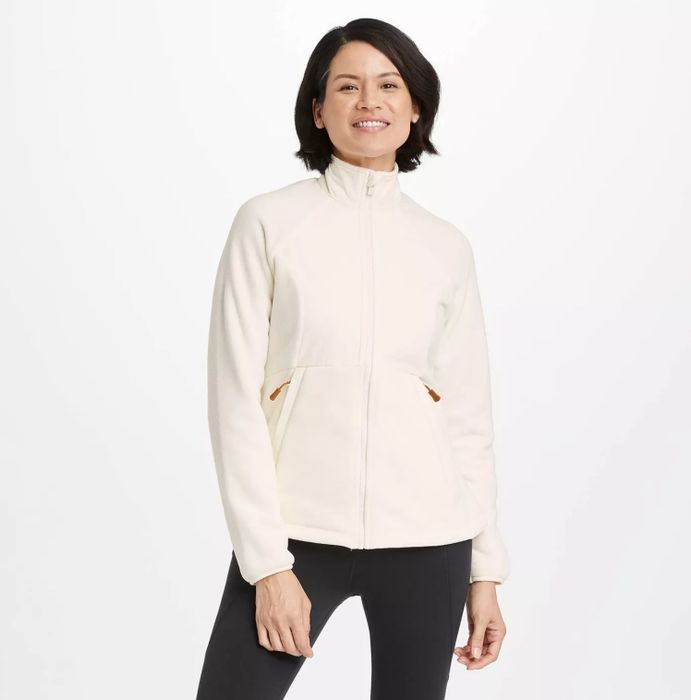 A model wearing the white jacket paired with sleek black leggings