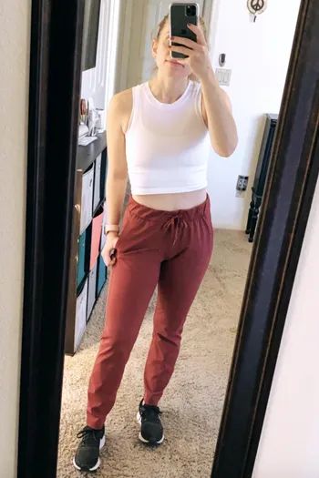 A reviewer showcasing high-waisted faded red drawstring lounge pants