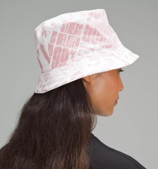 model wearing a white bucket hat with red lettering