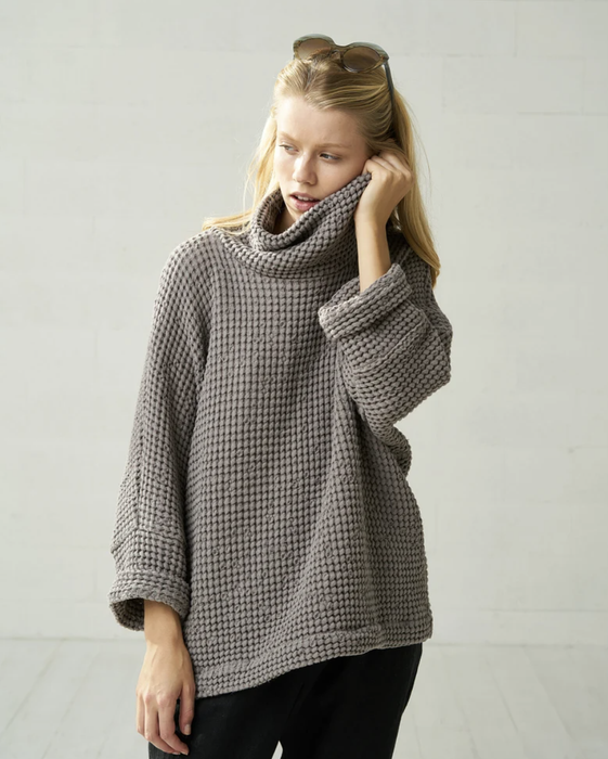 Stylist demonstrates the cozy knit paired with sleek onyx trousers
