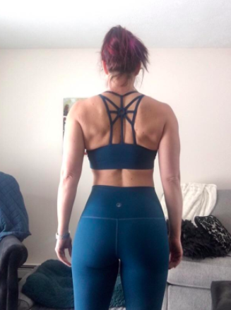The reviewer showcases the back of the same sports bra, emphasizing its stunning criss-cross back detailing.