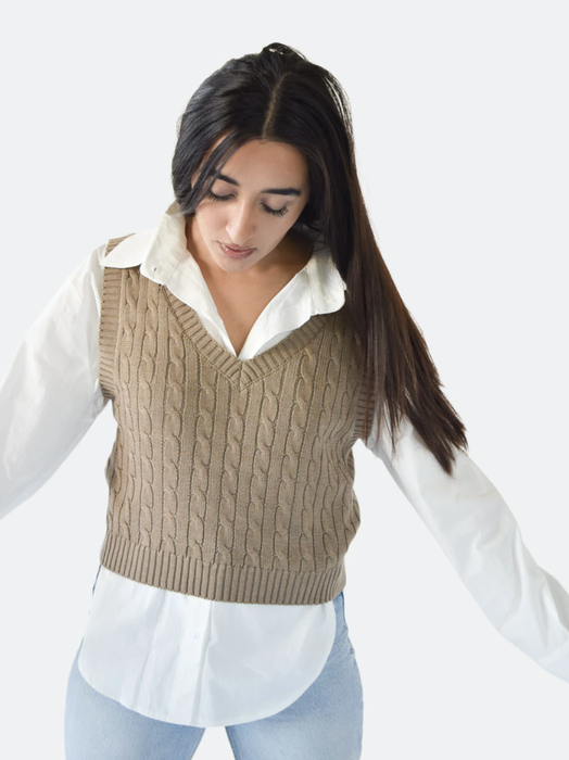 A fashion editor layers the knit vest atop a pristine white blouse