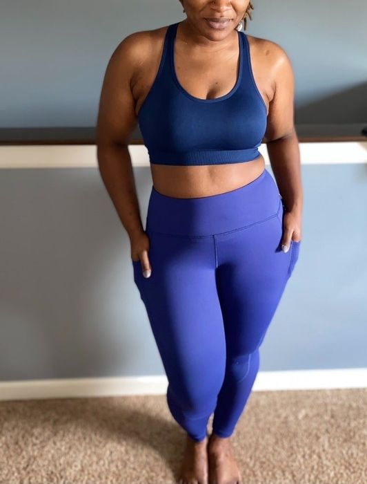 Reviewer in a sporty blue tank top and leggings standing confidently