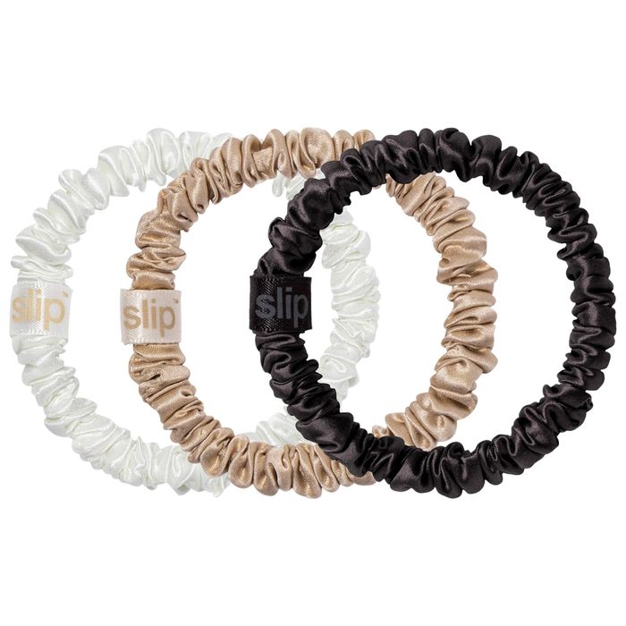 Three Slip-branded silk scrunchies in white, beige, and black, ideal for fashion and hair care features.
