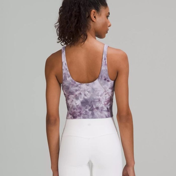 A model wearing the same athletic tank top in a lavender tie-dye pattern.