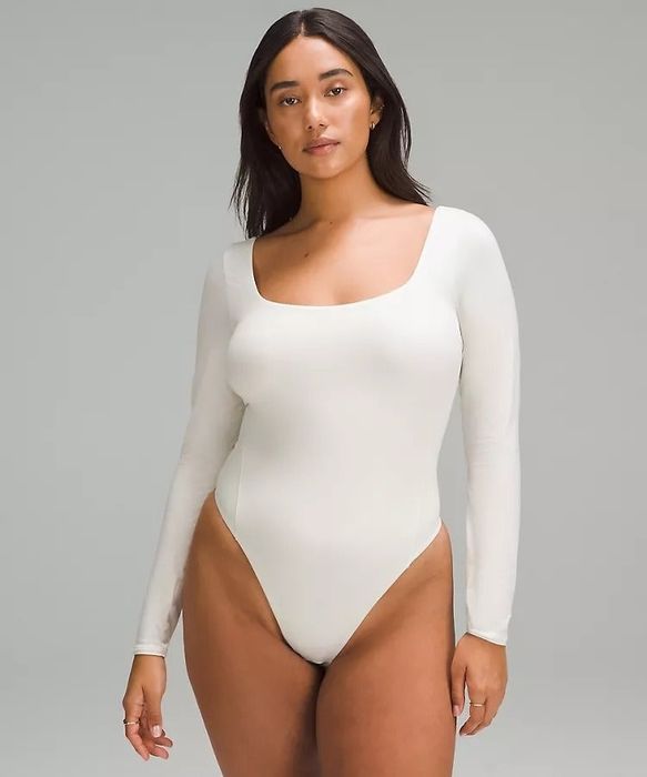 A model wearing the white long-sleeve bodysuit
