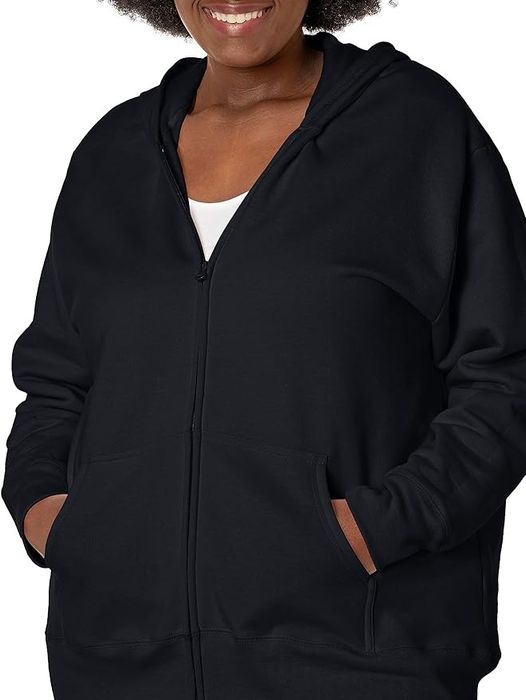 Model wearing a simple black zip-up hoodie with pockets, cropped at the neck