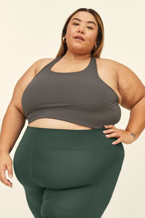 A model wearing the mid-length scoop neck sports bra in gray