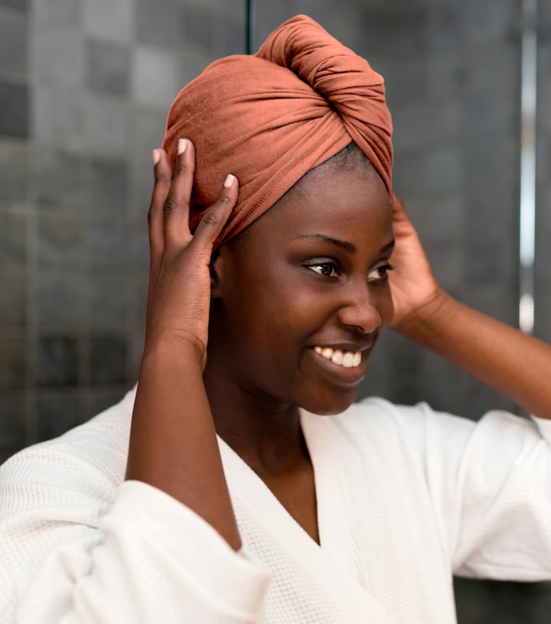 Model wearing the burnt orange t-shirt towel wrapped around their head