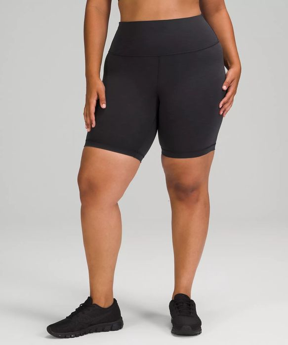 A model wearing black, long-length shorts.