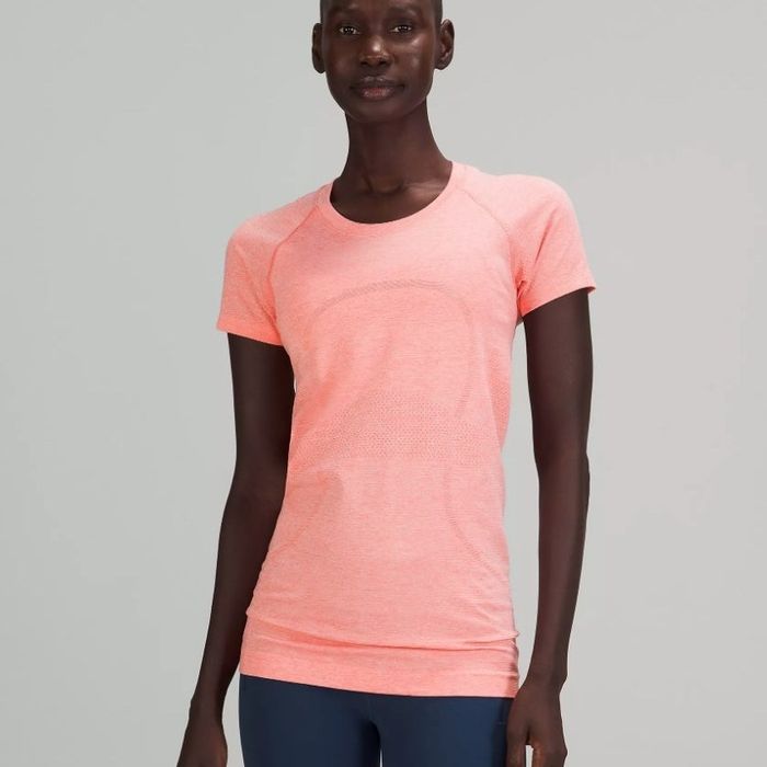 A model sporting an athletic short-sleeve tee in light pink.