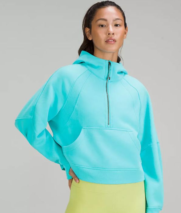 A model wearing a bright teal half-zip sweater.