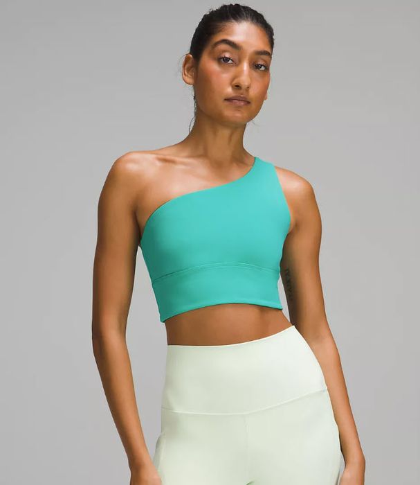 model in a dark teal one-shoulder crop top